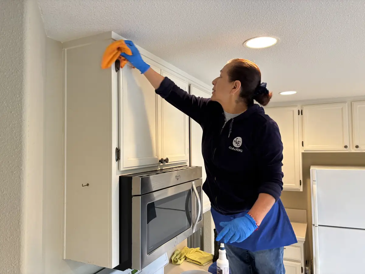 J&E cleaner wiping kitchen cabinets