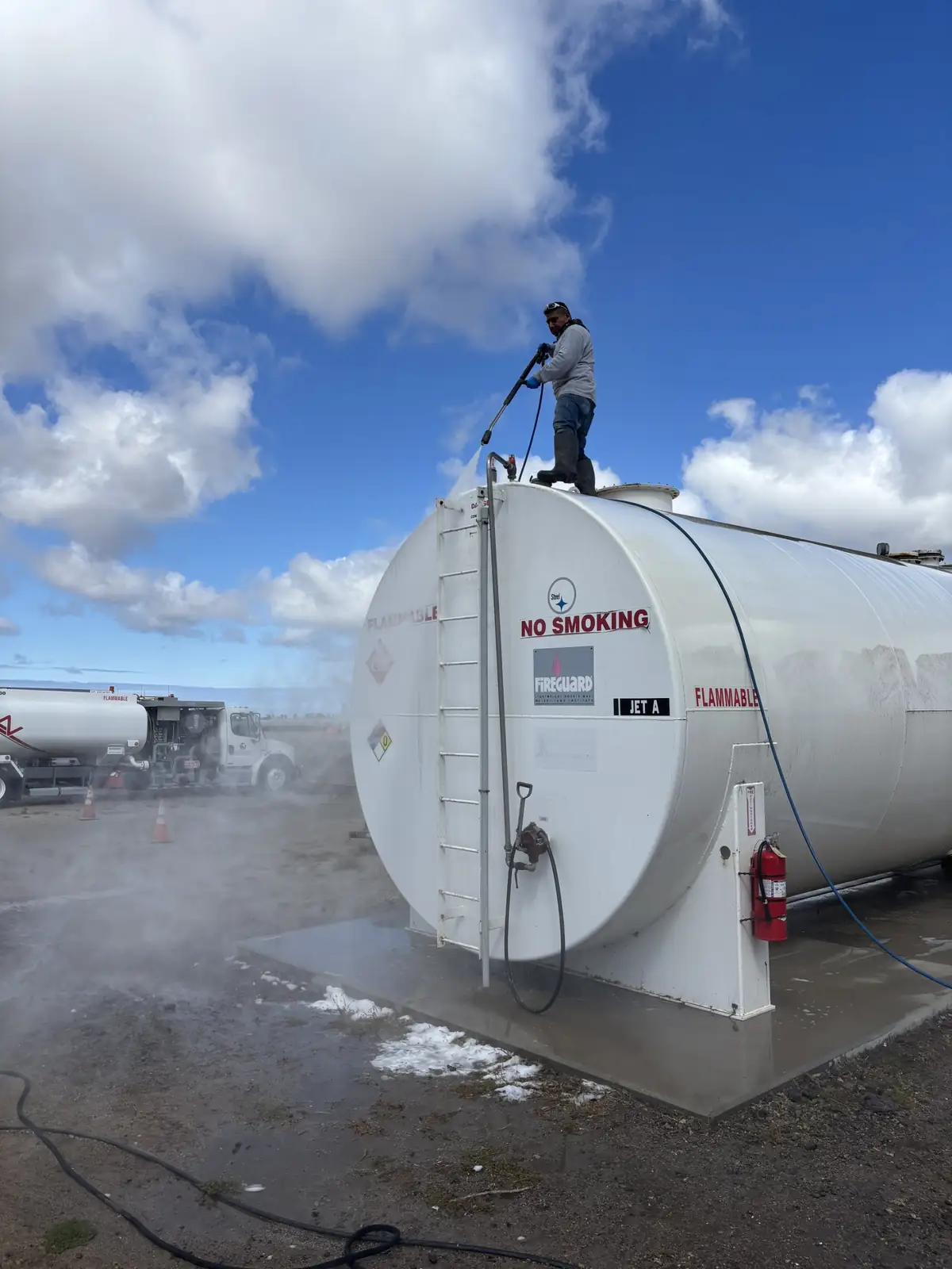 J&E crew member pressure washing a Jet A aviation fuel tank