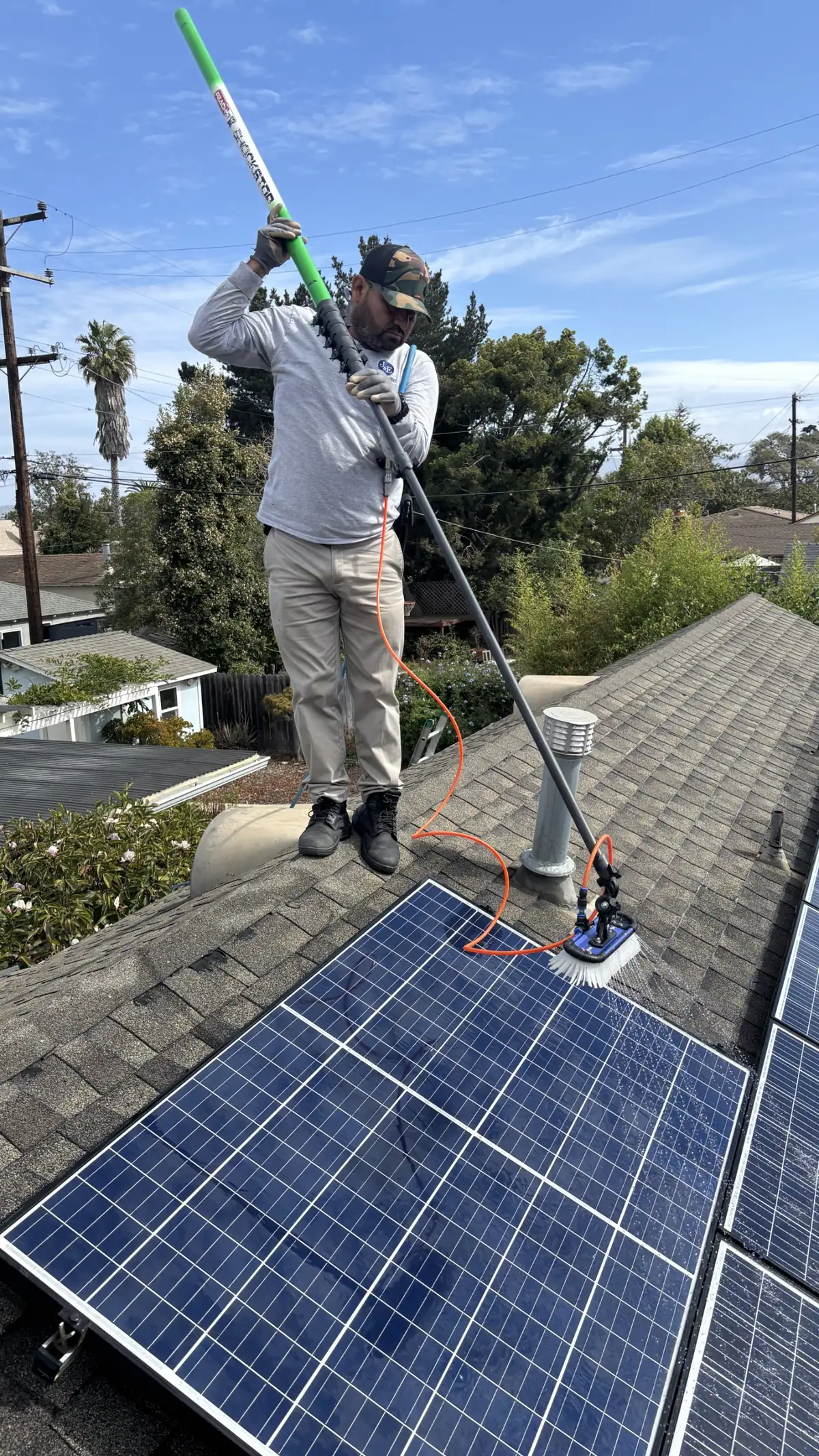J&E technician washing rooftop solar panels