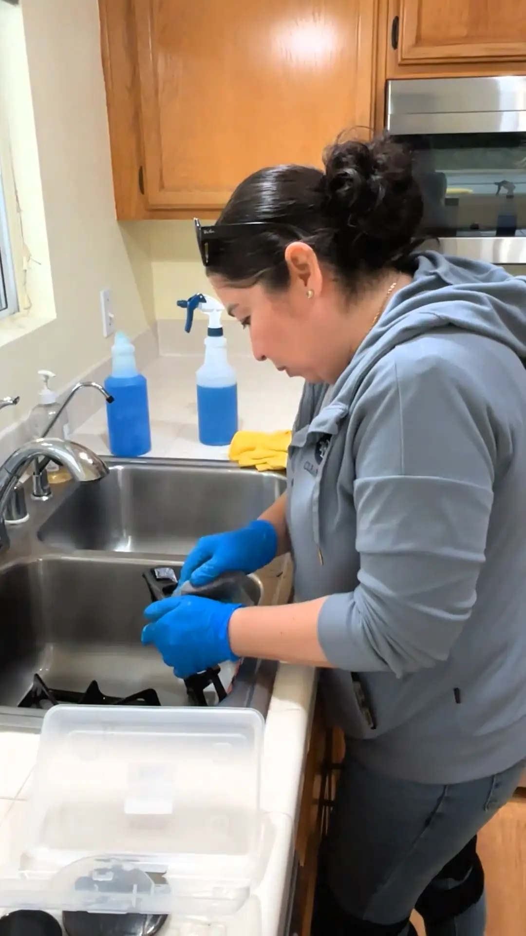 Scrubbing gas stove grates in a kitchen sink